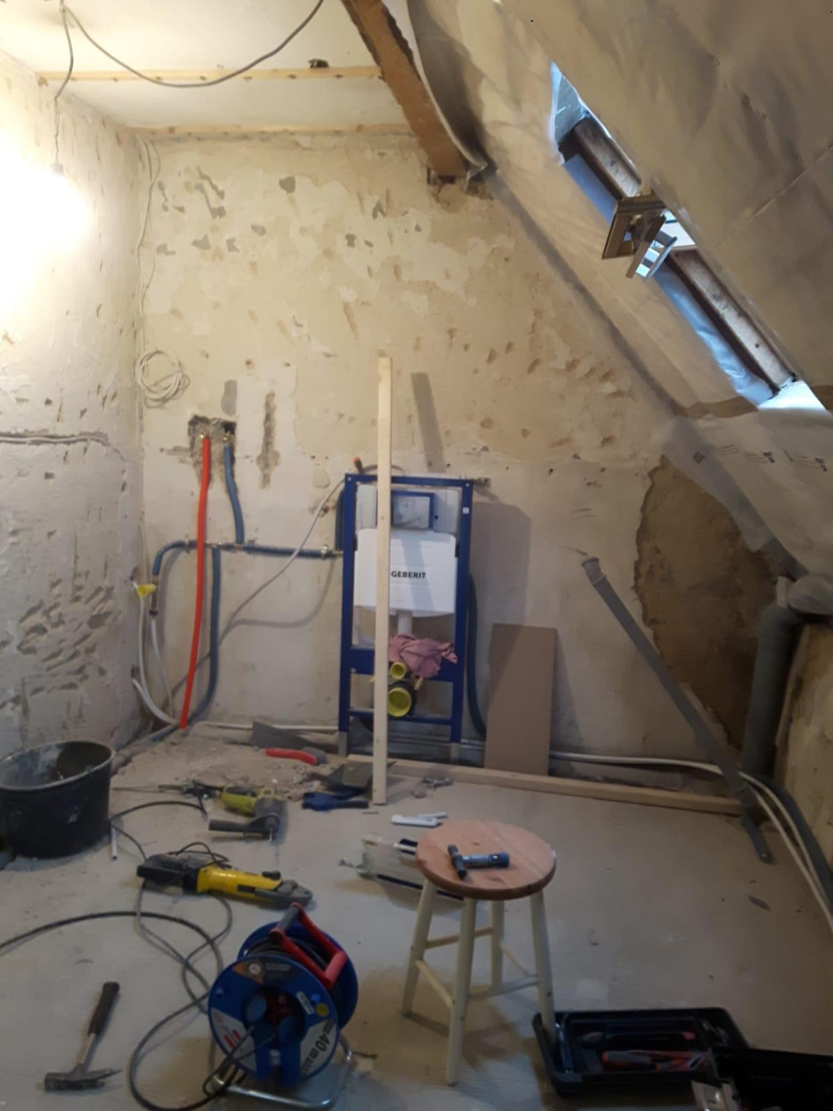 Råt badeværelse under renovering – vægge afrensede med synlige rør og kabler