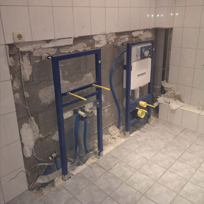 Råbyg med to Geberit-rammer og synlige rør under installation