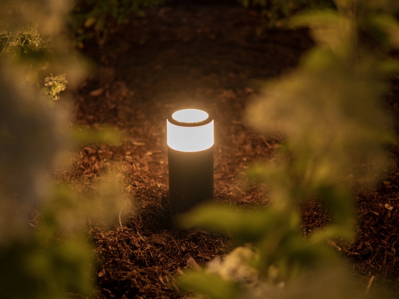 A glowing garden path light illuminates a walkway at night, demonstrating effective outdoor pathway lighting.