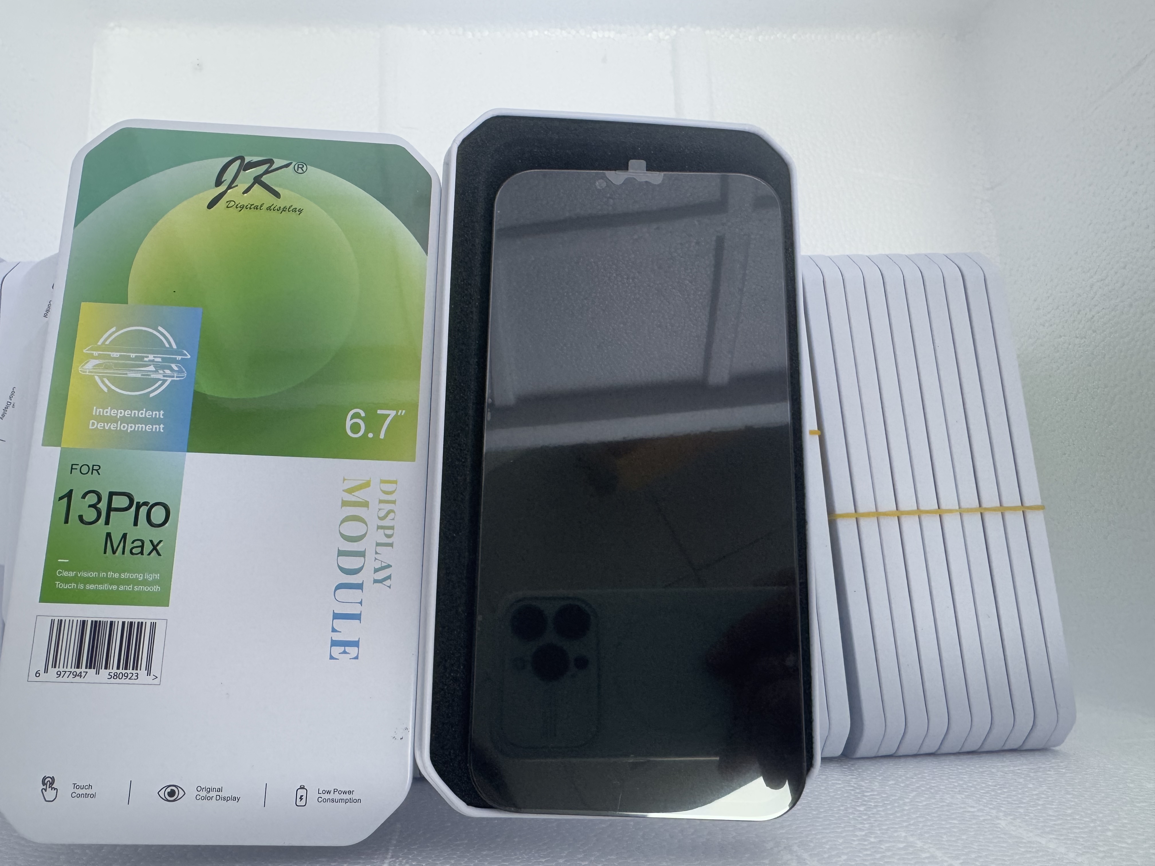 iPhone screen assembly removed from packaging showing LCD module and touch digitizer.