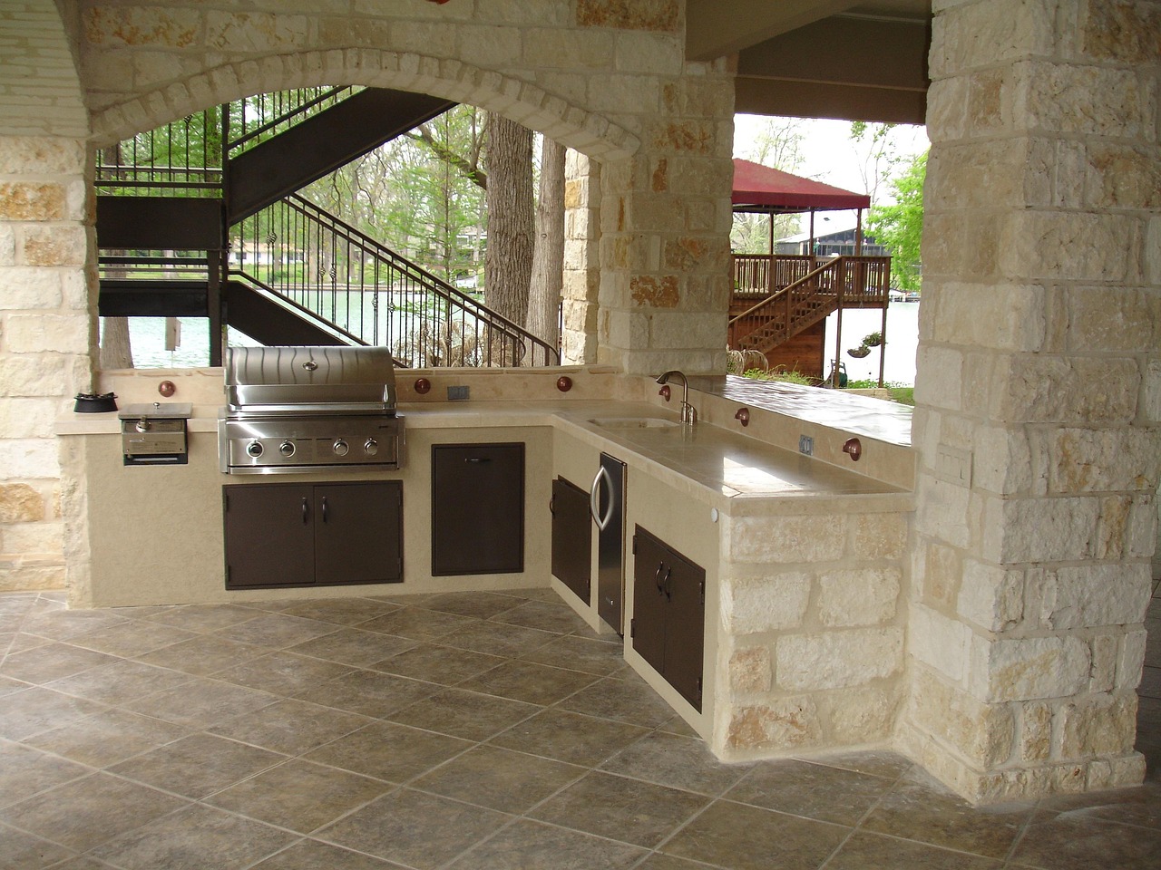 Outdoor kitchen with stainless steel built-in grill and stone masonry