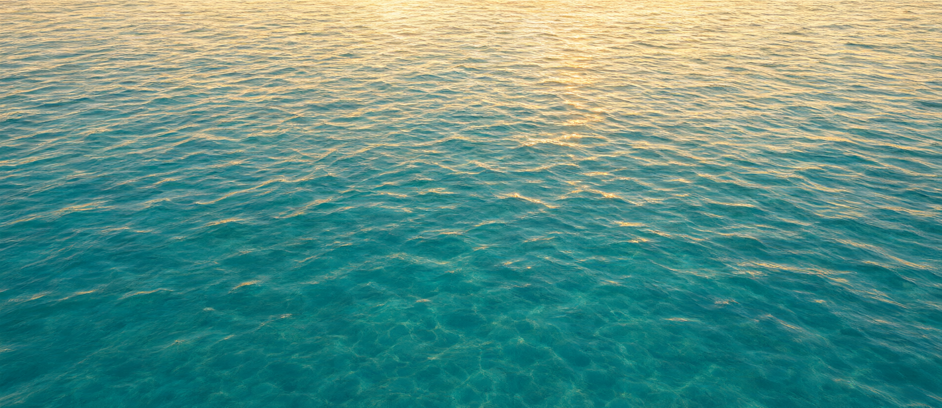 Warm editorial photograph of rippling turquoise ocean water