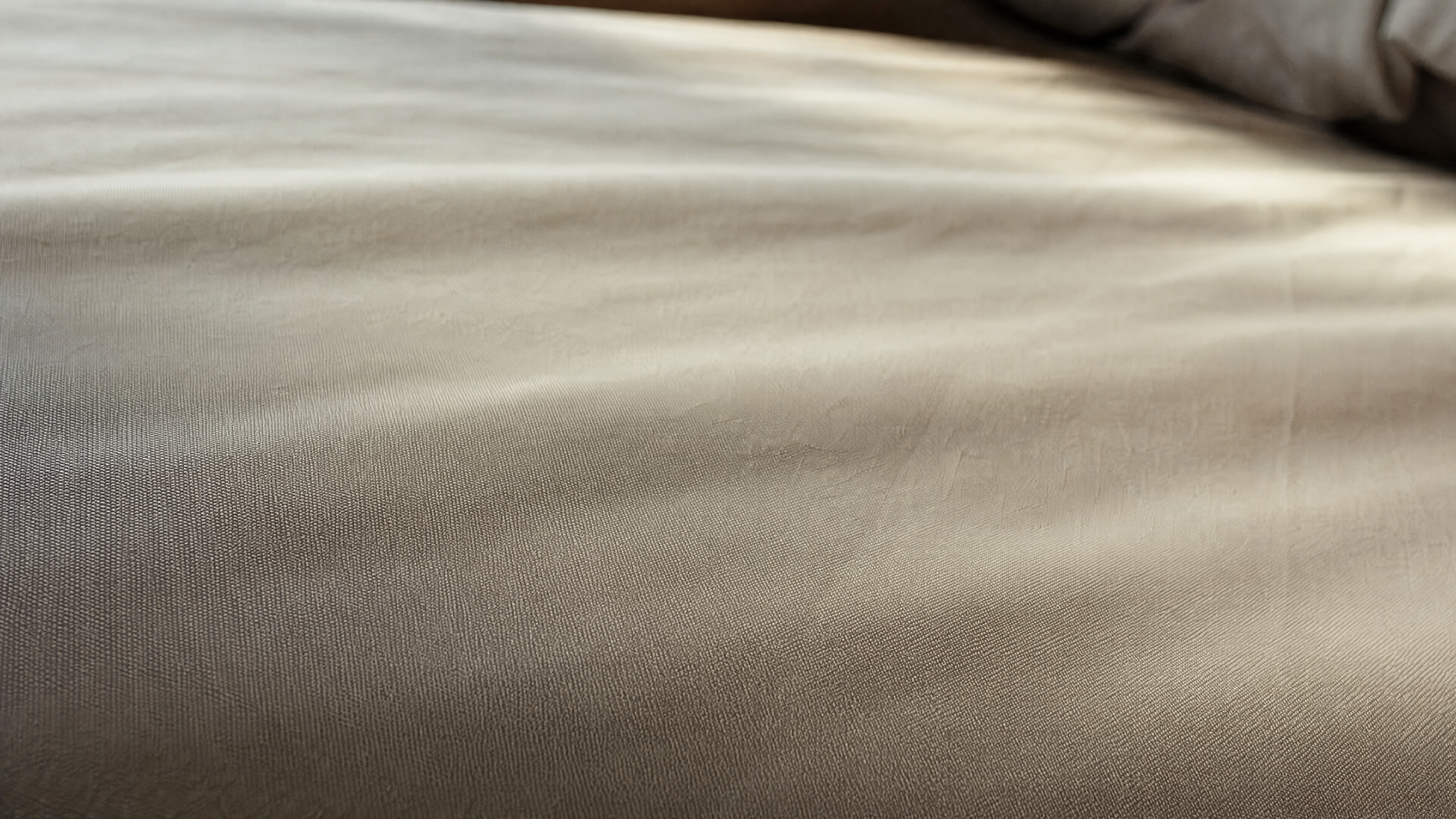 Close-up of LuxClub double-brushed microfiber sheets showing buttery-soft silky surface texture with subtle directional sheen in natural morning light